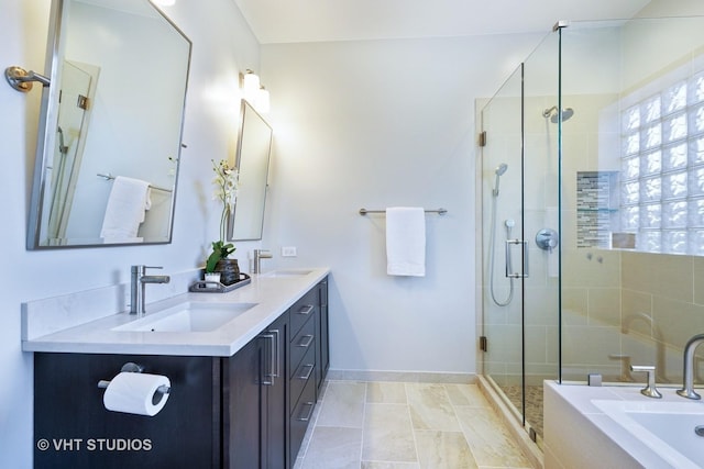 bathroom with a shower stall, a bath, and a sink