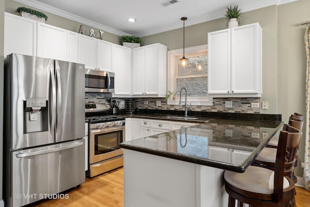 kitchen with a sink, a peninsula, backsplash, and stainless steel appliances