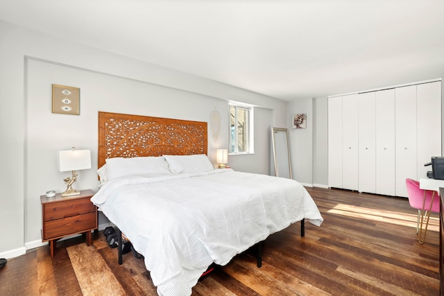 bedroom featuring wood finished floors, baseboards, and a closet