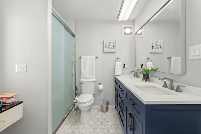 full bath with a sink, toilet, double vanity, and tile patterned flooring