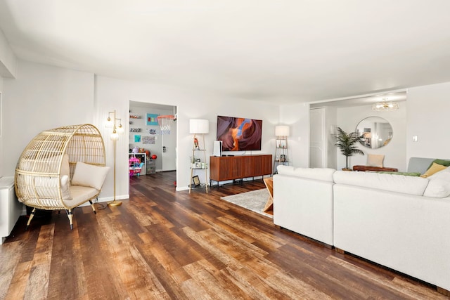 living room with an inviting chandelier, baseboards, and wood finished floors