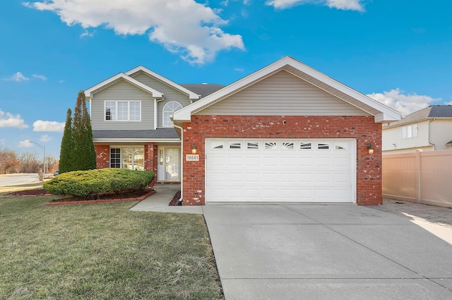 traditional-style house featuring brick siding, fence, a front yard, a garage, and driveway