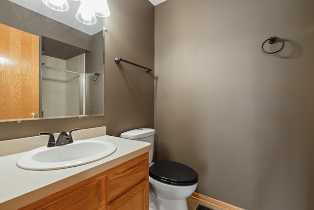 bathroom with vanity, toilet, and a shower stall