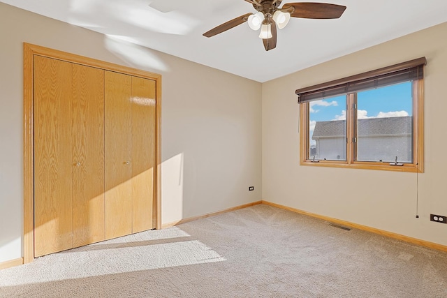 unfurnished room featuring light carpet, visible vents, baseboards, and ceiling fan