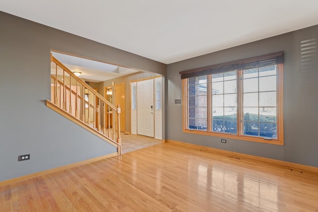 interior space with stairway, baseboards, and wood finished floors