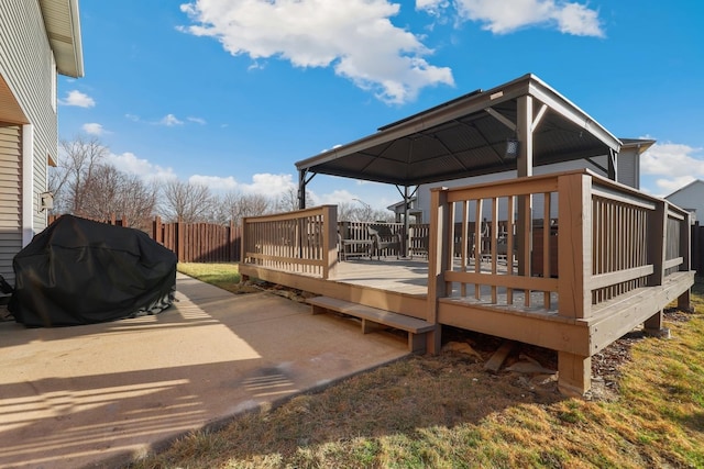 wooden terrace featuring a patio area, fence, and grilling area