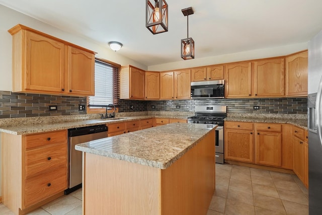 kitchen featuring a sink, tasteful backsplash, appliances with stainless steel finishes, and a center island