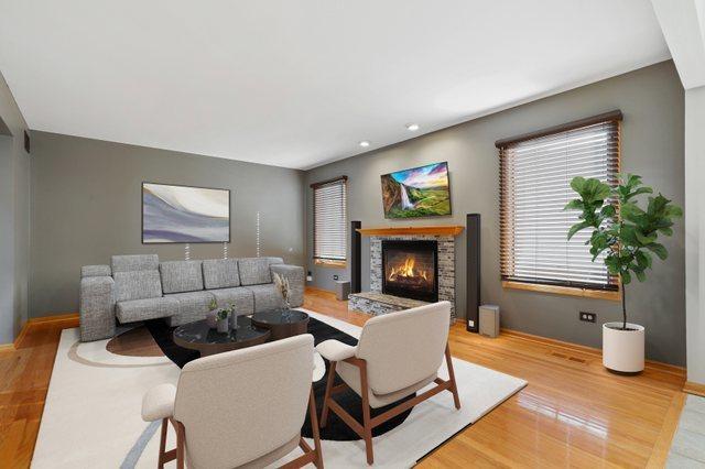 living area with wood finished floors and a lit fireplace