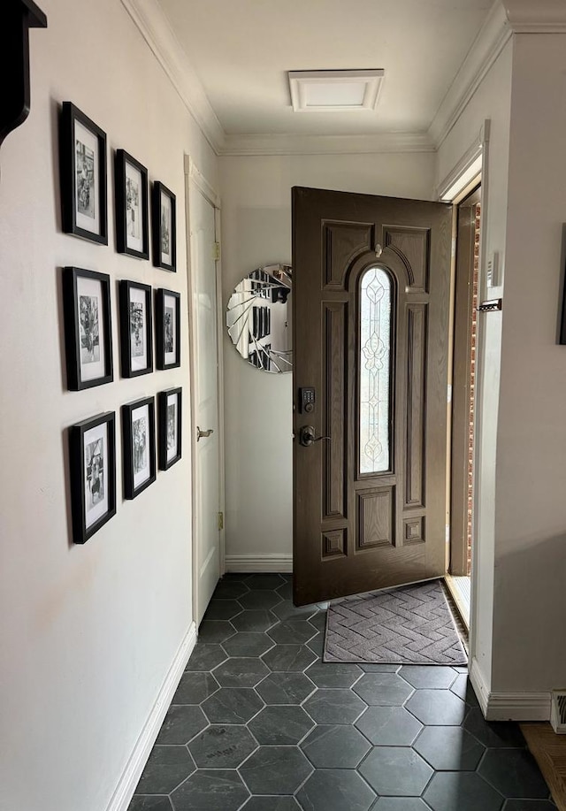 entryway with baseboards and ornamental molding