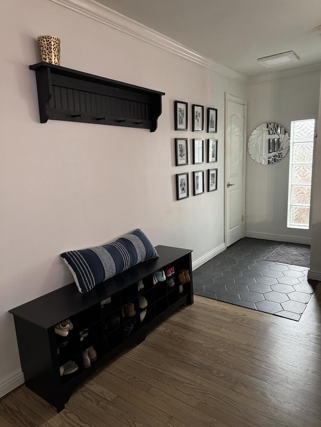 mudroom featuring dark wood-style floors, crown molding, and baseboards