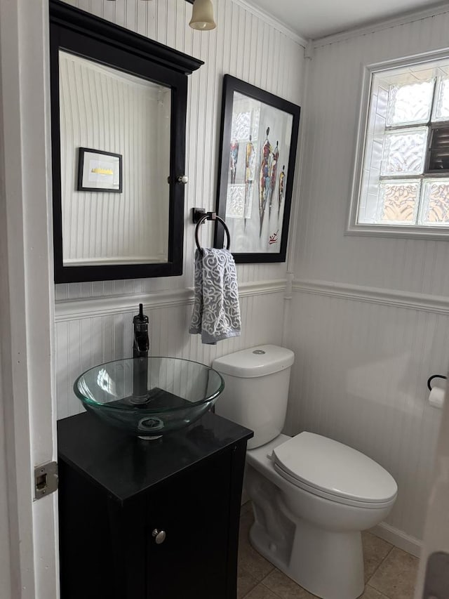 bathroom featuring tile patterned floors, toilet, wainscoting, and vanity