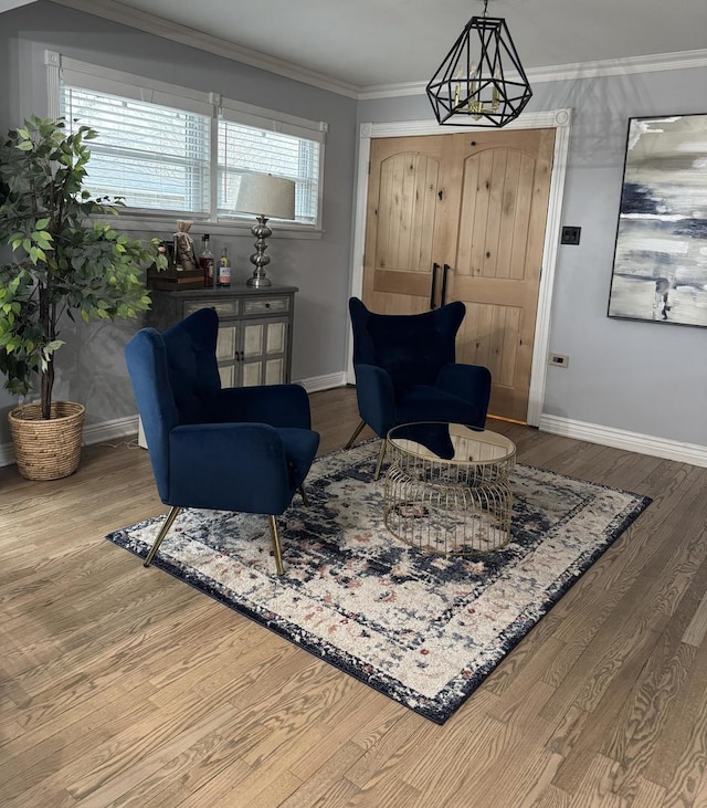 living area with crown molding, baseboards, and wood finished floors