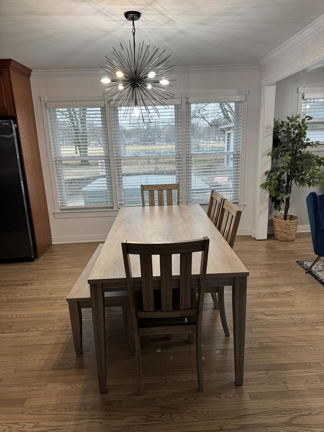 dining space with crown molding, a notable chandelier, and dark wood-type flooring