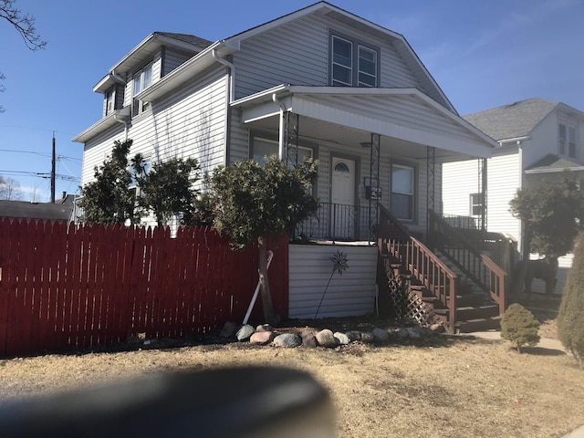 view of front facade with a porch and fence