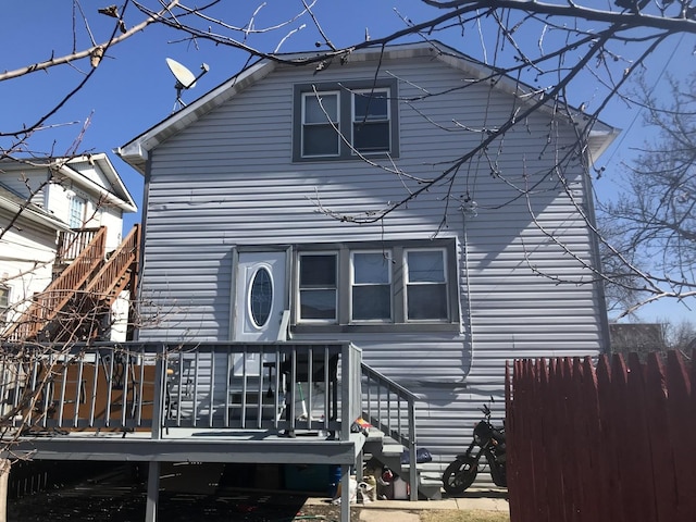 rear view of property with a deck and fence