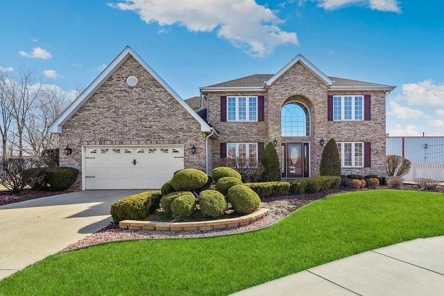 view of front of house with brick siding, a front yard, concrete driveway, and an attached garage