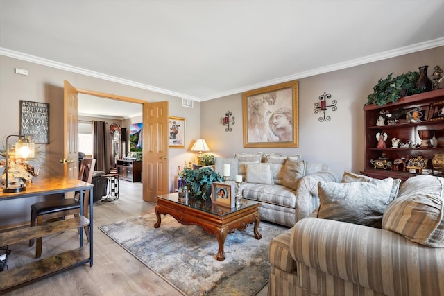 living area with visible vents, light wood finished floors, and ornamental molding