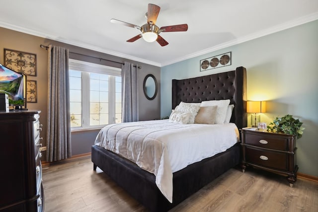 bedroom featuring ceiling fan, crown molding, baseboards, and wood finished floors