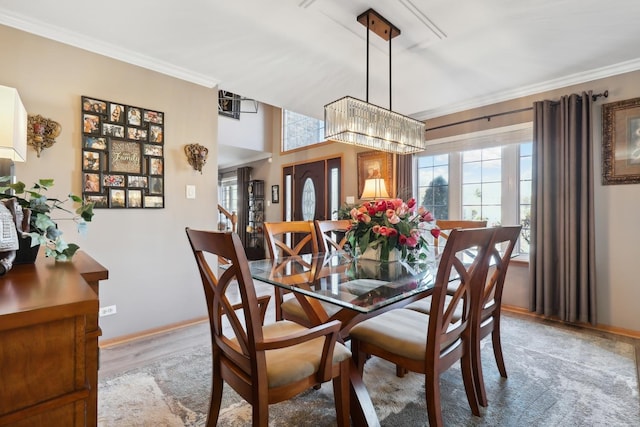 dining area with wood finished floors, baseboards, and ornamental molding