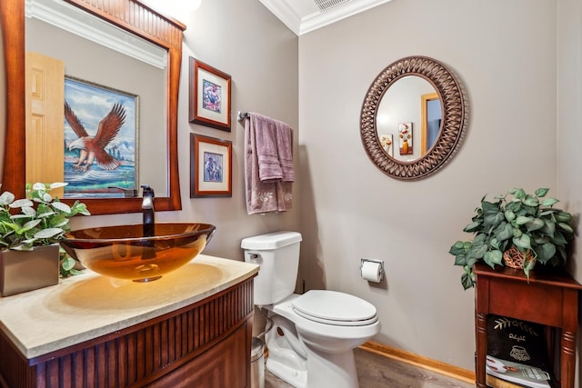 bathroom featuring vanity, visible vents, baseboards, ornamental molding, and toilet