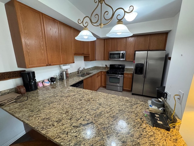 kitchen with brown cabinets, a peninsula, stone countertops, stainless steel appliances, and a sink