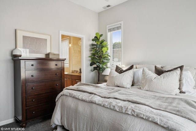 bedroom featuring ensuite bath, carpet, visible vents, and baseboards