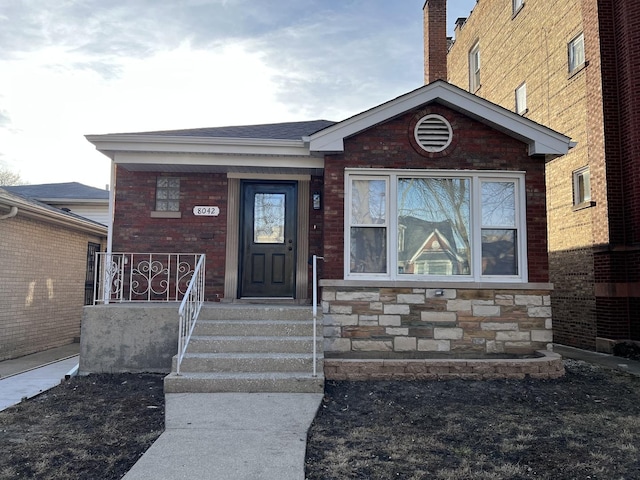 doorway to property featuring brick siding and stone siding