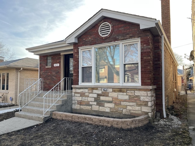 view of front of property with brick siding, stone siding, and a chimney