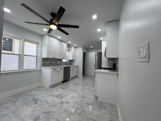 kitchen featuring tasteful backsplash, dishwasher, light countertops, white cabinets, and a sink