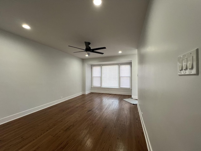 spare room featuring recessed lighting, baseboards, a ceiling fan, and dark wood-style flooring