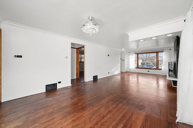 unfurnished living room with baseboards, wood finished floors, visible vents, and ornamental molding