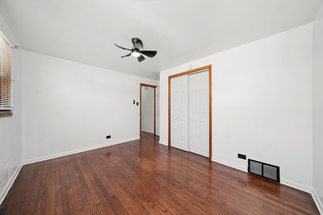 unfurnished bedroom with a closet, visible vents, baseboards, and wood finished floors