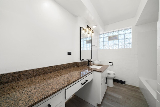 full bathroom featuring vanity, tile walls, toilet, and wood finished floors