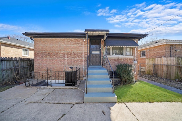 bungalow with brick siding and fence