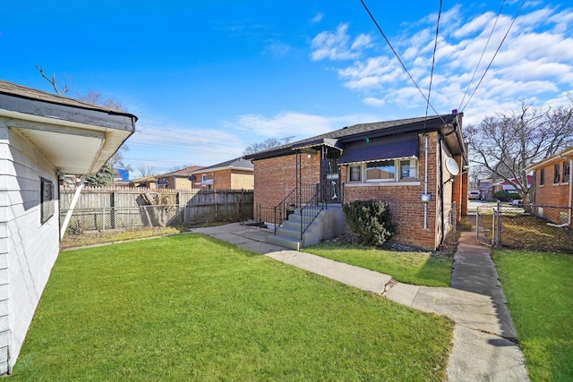 exterior space with brick siding, a front lawn, and fence