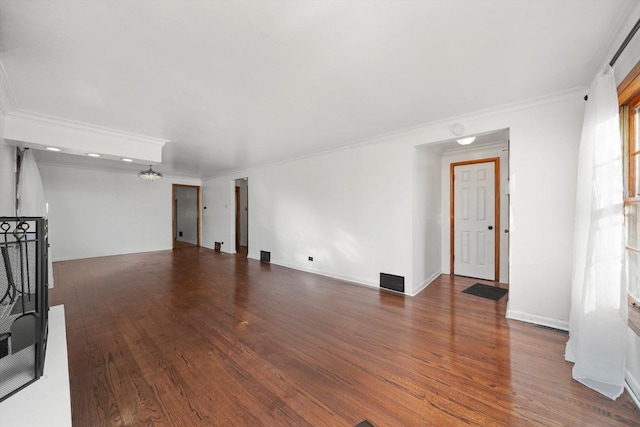 unfurnished living room with visible vents, baseboards, wood finished floors, and crown molding