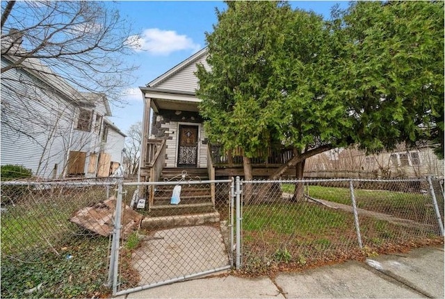 view of front of home featuring a fenced front yard, covered porch, and a gate