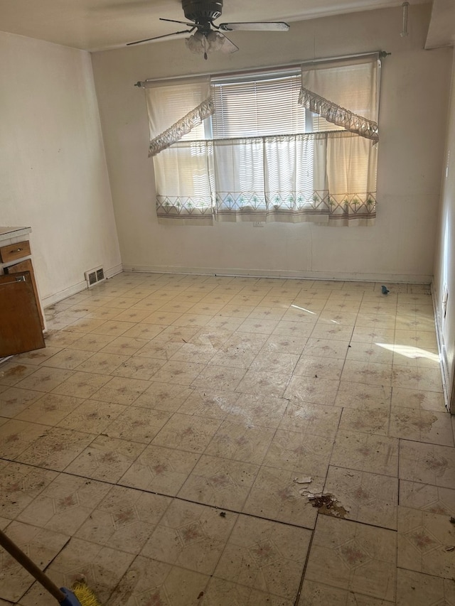 empty room with plenty of natural light, light floors, visible vents, and a ceiling fan