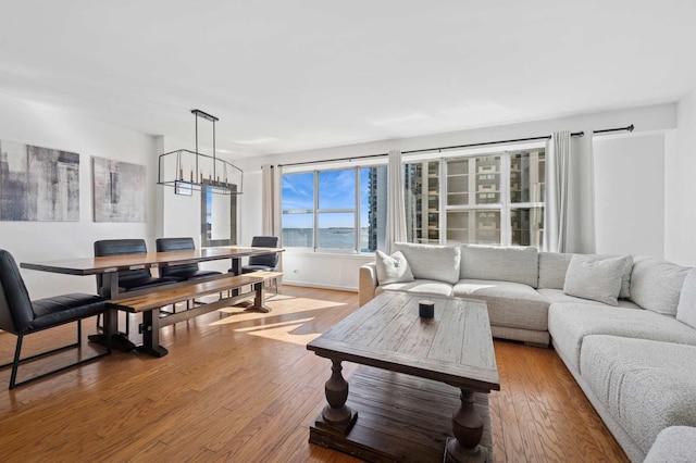 living area with light wood finished floors and a notable chandelier