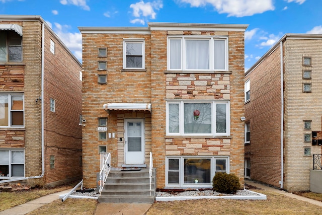 townhome / multi-family property with brick siding and stone siding