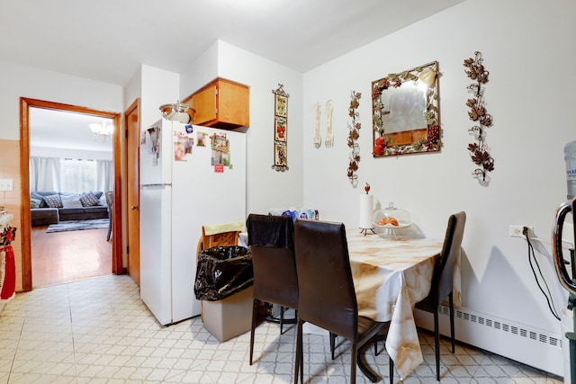 dining room featuring baseboard heating and light floors