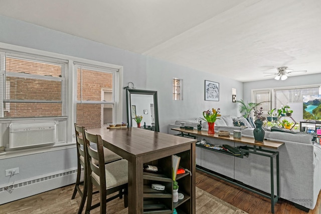 dining area featuring a baseboard heating unit, cooling unit, ceiling fan, and hardwood / wood-style flooring