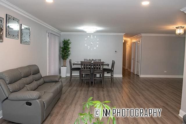 dining space with baseboards, wood finished floors, and crown molding