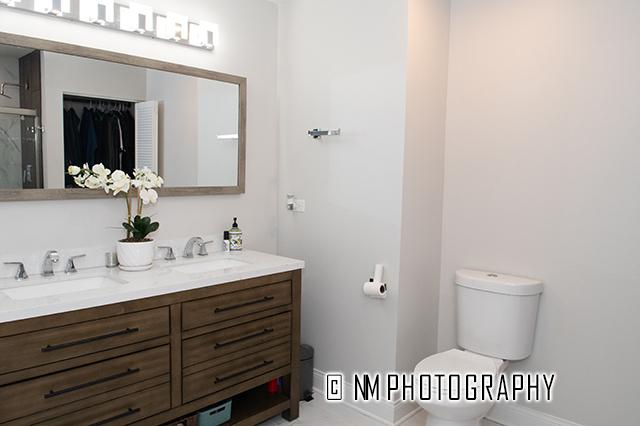 bathroom featuring a sink, an enclosed shower, toilet, and double vanity