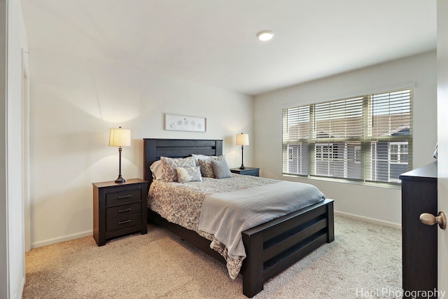 bedroom featuring baseboards and light colored carpet