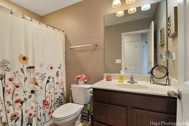 bathroom featuring curtained shower, toilet, and vanity