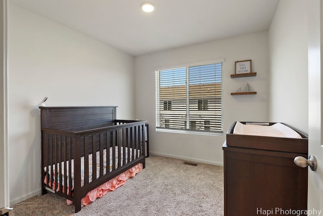 bedroom featuring visible vents, baseboards, and carpet