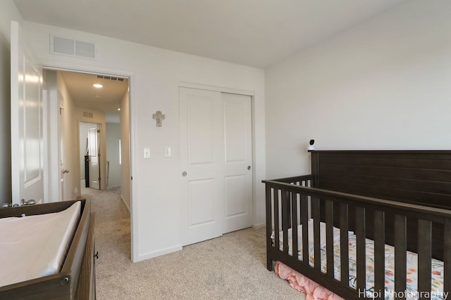 bedroom with baseboards, visible vents, carpet floors, and a closet