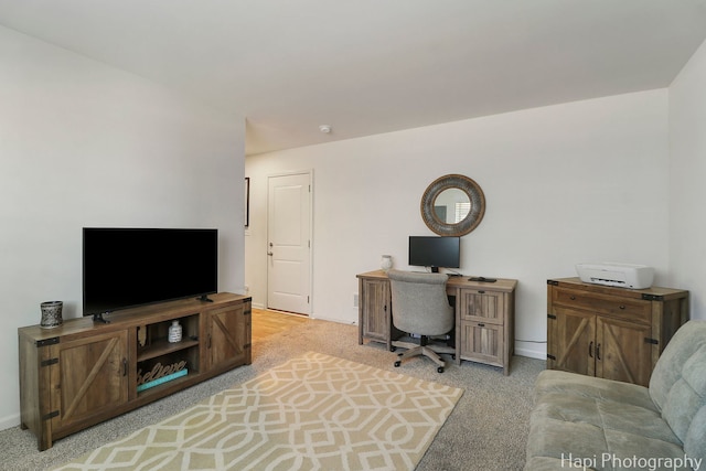 home office with baseboards and light colored carpet