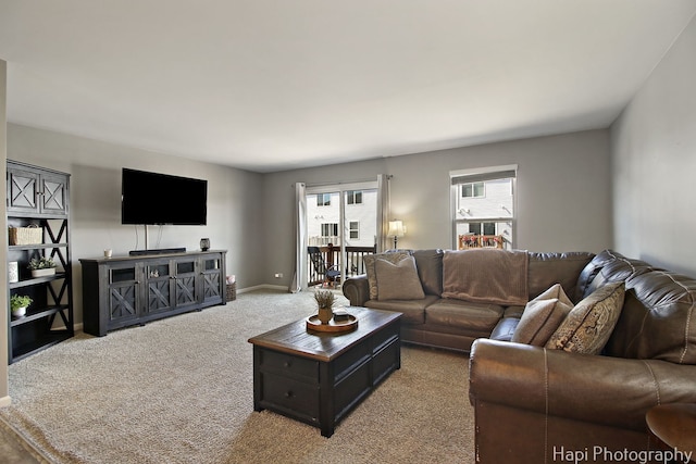 carpeted living room featuring baseboards